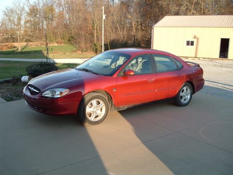 2001 Ford Taurus - Red 2001 Ford Taurus parked on a driveway in front of a detached garage.
