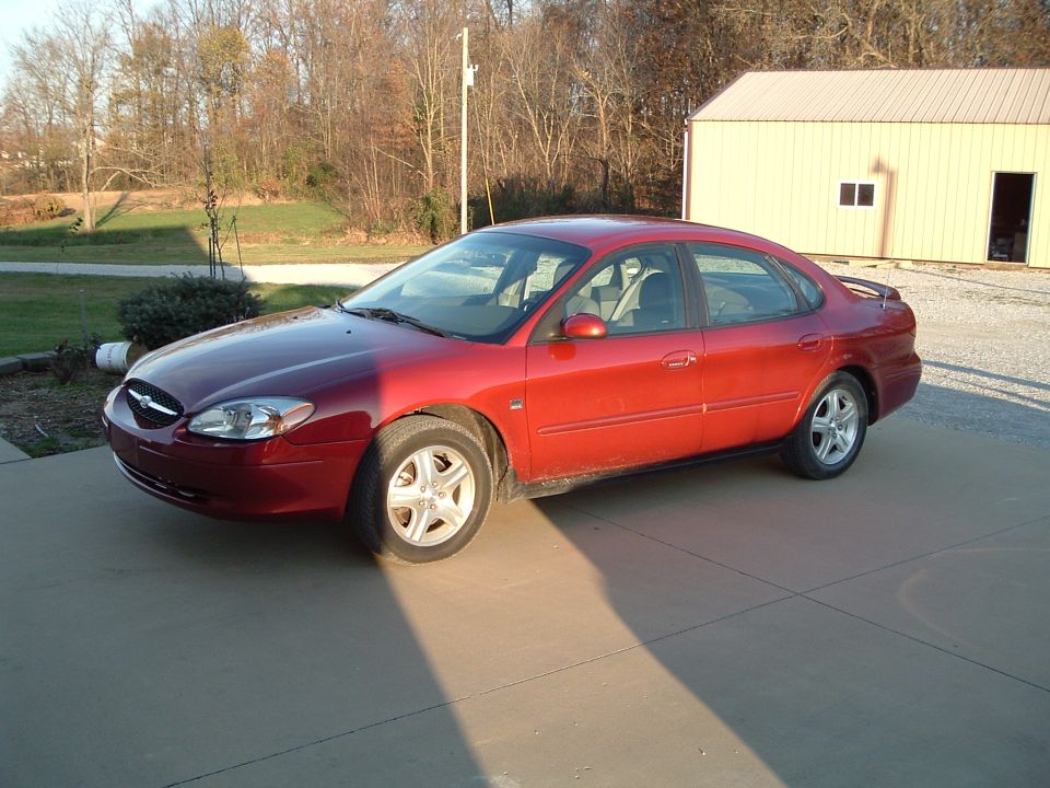 Red 2001 Ford Taurus parked in front of a building