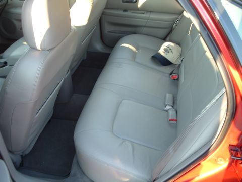 2001 Ford Taurus - Interior view of the rear seats of a 2001 Ford Taurus, showing tan leather upholstery and a baseball cap.