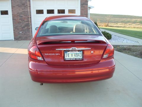 2001 Ford Taurus - Rear view of a red 2001 Ford Taurus SEL sedan parked in front of a garage.