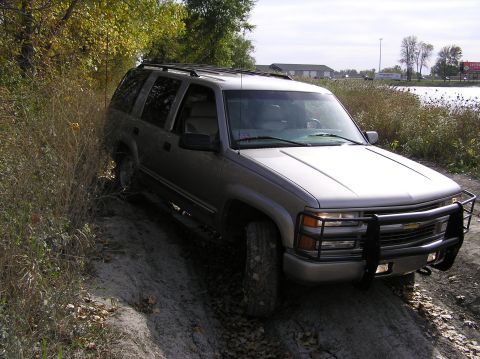 2000 Chevrolet Tahoe - This SUV is off-road on a dirt path with dry vegetation surrounding it.