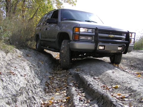 2000 Chevrolet Tahoe - This SUV navigates a rough dirt path, showing off its off-road capabilities.