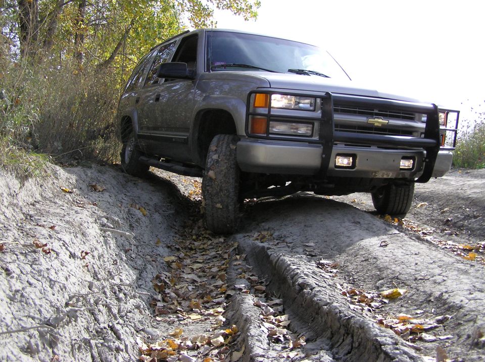 Gray SUV with bull bar driving on a dirt road