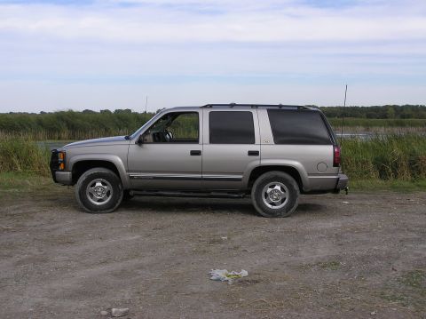 2000 Chevrolet Tahoe - Side view of a silver Chevrolet Tahoe SUV parked outdoors near a body of water.