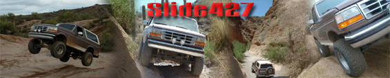Brown Ford Bronco mid-air over dirt terrain