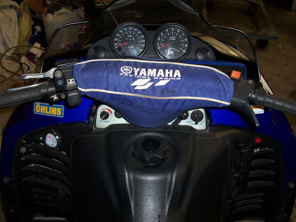 Yamaha snowmobile cockpit with Ohlins gauges and a blue Yamaha Factory Racing pad