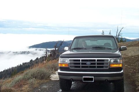 1995 Ford Bronco - A 1995 Ford Bronco is parked on a mountain overlook with fog covering the valleys below.