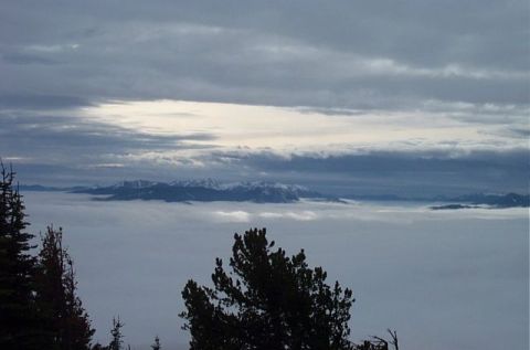 1995 Ford Bronco - A cloudy day with mountains visible above a layer of fog.