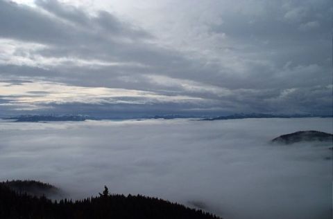 1995 Ford Bronco - A vast expanse of clouds blankets the landscape, with distant mountains peeking through the overcast sky.