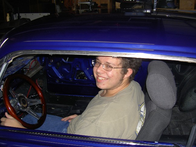 1965 Ford Mustang interior with man at the wheel, blue exterior