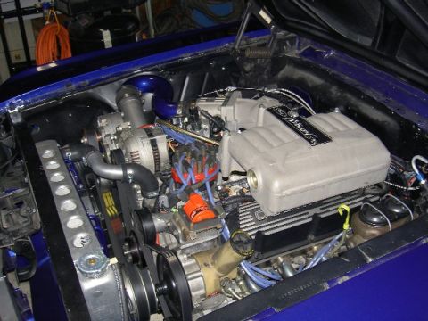 1965 Ford Mustang - Close-up of a V8 engine in a vehicle's engine bay, custom modifications.