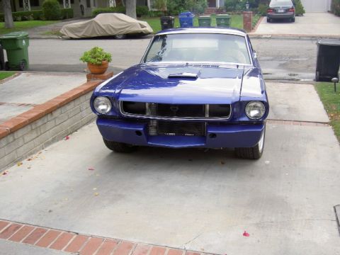 1965 Ford Mustang - Front view of a blue 1965 Ford Mustang coupe in a residential driveway.
