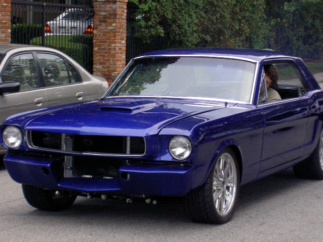 Blue 1965 Ford Mustang coupe with hood scoop and custom wheels