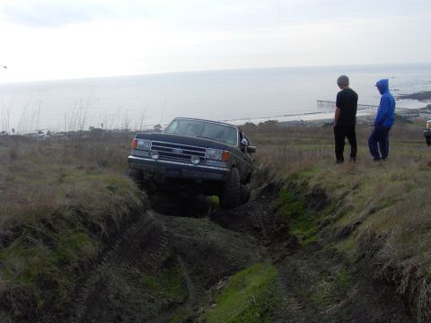 1998 Ford Ranger - A Ford pickup truck navigates a challenging muddy path with the ocean in the background.
