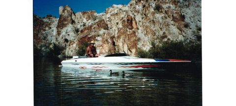 1991 Ford Bronco - A person enjoys a ride on a speed boat with ducks swimming nearby, set against a backdrop of rocky cliffs.