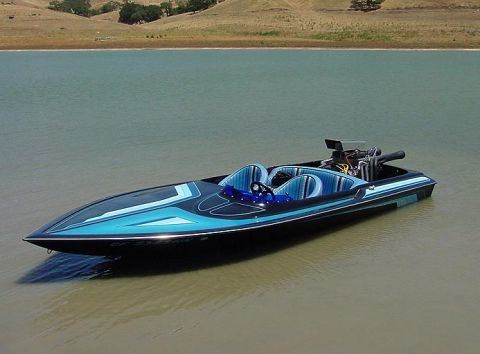 1991 Ford Bronco - A speed boat with a powerful exposed engine sits on the water under a clear sky.