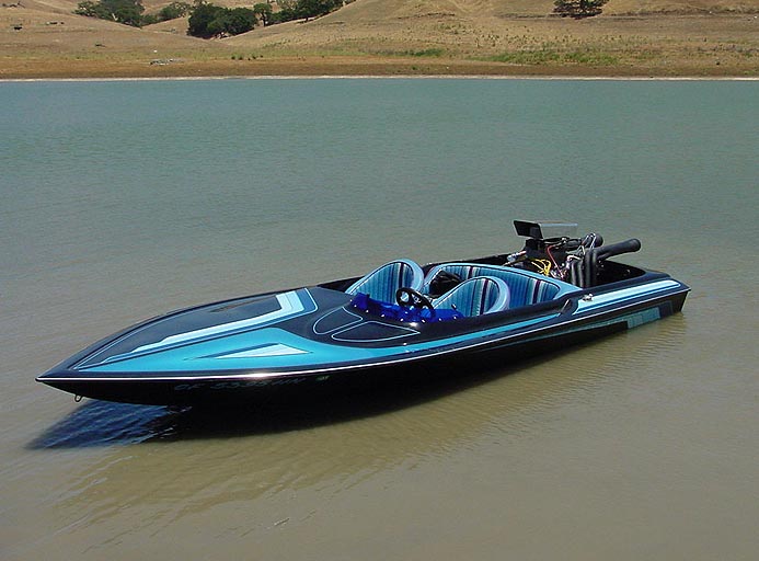 Speed boat with blue and black paint scheme, exposed engine, and two seats, floating on water