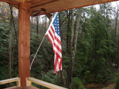 1989 Ford Bronco - American flag displayed on a porch overlooking a wooded area. Supermotors.net logo is present.