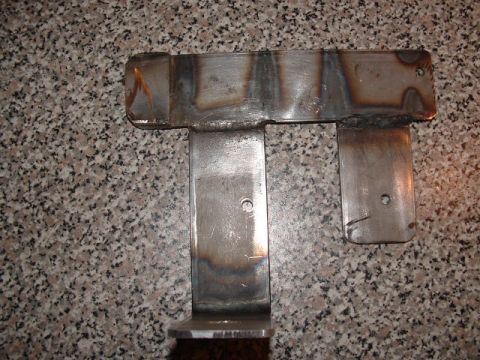 1990 Ford Bronco - A custom metal bracket with visible welding marks and mounting holes is shown against a granite-like background.