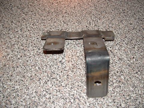 1990 Ford Bronco - A metal bracket, possibly for a dual battery setup, is shown against a speckled background.