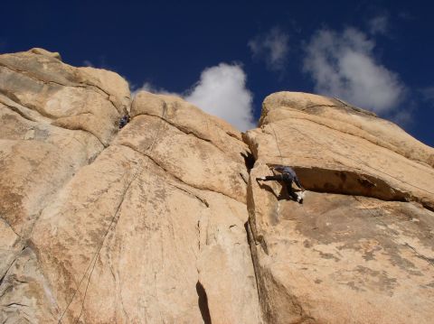 1990 Ford Bronco - Climbers ascend a sheer rock face, utilizing ropes and their hands to navigate the challenging terrain.