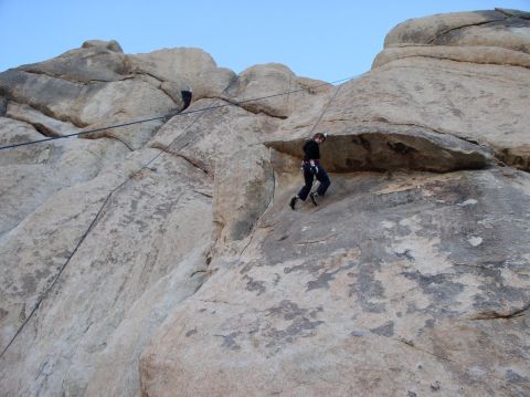 1990 Ford Bronco - Two people are rock climbing on a large rock face with ropes and harnesses.