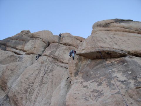 1990 Ford Bronco - Several individuals are rock climbing on a large rock face with ropes and harnesses.