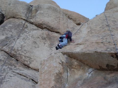1990 Ford Bronco - A person climbs a rock face, using ropes for safety. The image includes a Supermotors.net watermark.