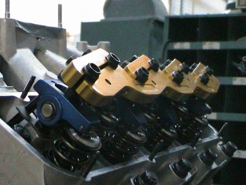 1979 Ford Bronco - Close-up view of an engine's valve train, gold rocker arms and blue components.
