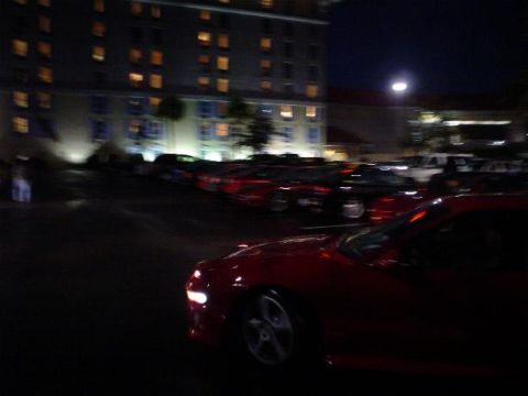1996 Ford Probe - A red car is parked in a lot at night, with a building in the background.