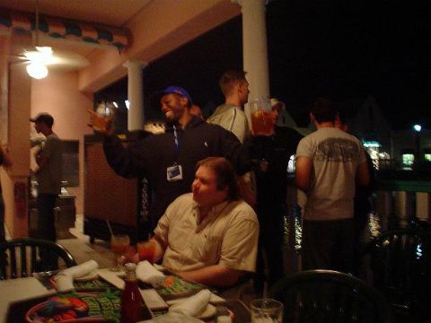 1996 Ford Probe - A group of people are socializing on an outdoor patio at night, with drinks and food on the tables.