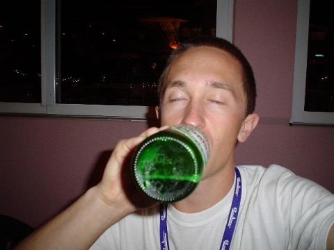 1996 Ford Probe - A man drinks from a green bottle while wearing a t-shirt with 'SUPERMOTORS' printed on it.