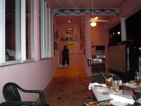 1996 Ford Probe - A person stands in a doorway of a pink building with outdoor seating and tables set for drinks.