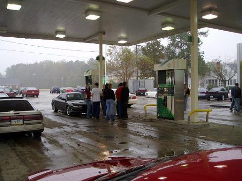 1996 Ford Probe - Several cars and people are at a gas station on a wet day, with BP pumps visible.