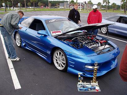 1996 Ford Probe - A blue 1996 Ford Probe is displayed with its hood open, showing the engine, at an outdoor event.