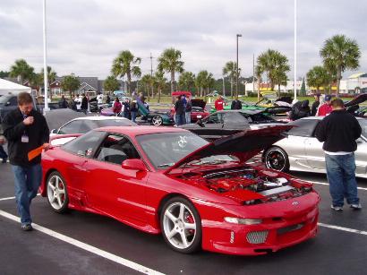 1996 Ford Probe - A red 1996 Ford Probe is displayed at a car show, with its engine compartment open for viewing.