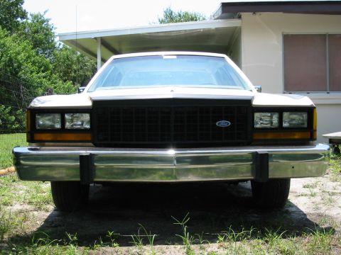 1985 Ford Crown Victoria LTD - Front view of a white 1985 Ford Crown Victoria LTD with a chrome bumper and black grille.