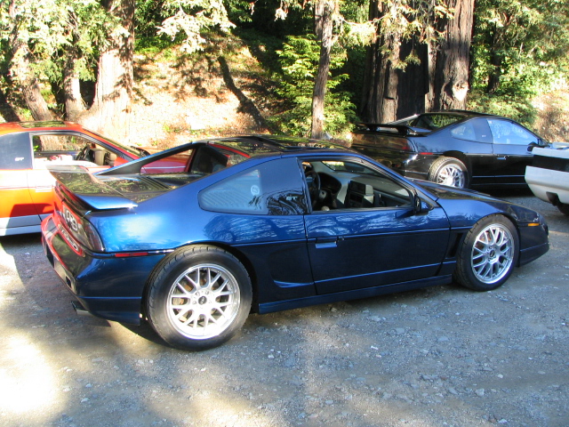 Blue 1986 Pontiac Fiero parked outdoors with other cars visible