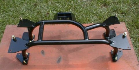 1990 Ford Bronco - This black metal frame part, possibly for a vehicle, is shown resting on a wooden board outdoors.