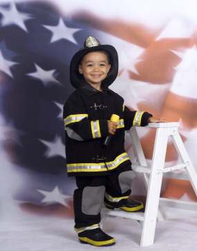 1989 Ford Bronco - Youngster in firefighter gear poses for a photo with an American flag background.
