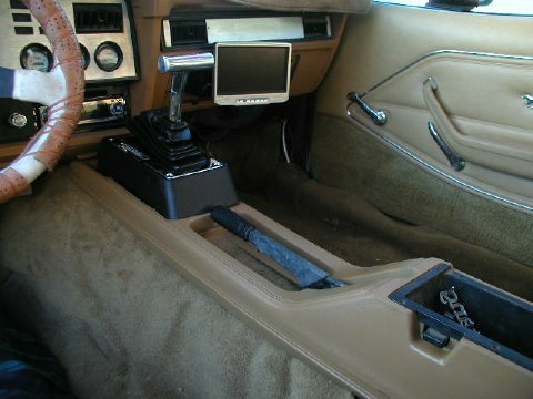 1978 Ford Mustang II - The interior of a car is shown, a floor-mounted shifter and a small display screen mounted on the dashboard.