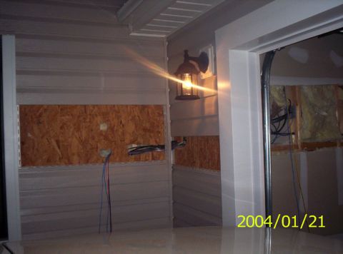 1986 Ford Bronco - Interior view of a garage under construction or renovation, showing exposed wiring and plywood sheeting on the walls.