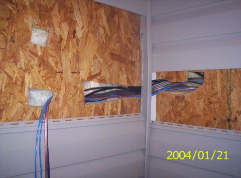 1986 Ford Bronco - Electrical wiring installation in progress, showing wires routed through an OSB wall panel.