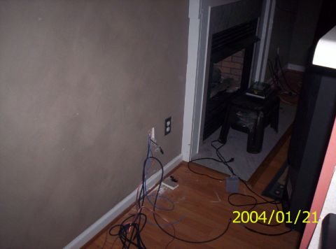 1986 Ford Bronco - Loose electrical wires are visible on the floor near an outlet and a fireplace.