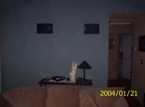 1986 Ford Bronco - A room scene shows a couch, a table with decorative items, and wall-mounted speakers.