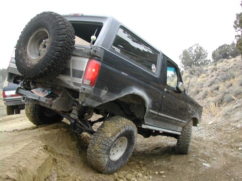 1994 Ford Bronco - This 1994 Ford Bronco is navigating a steep, muddy incline on a dirt trail.