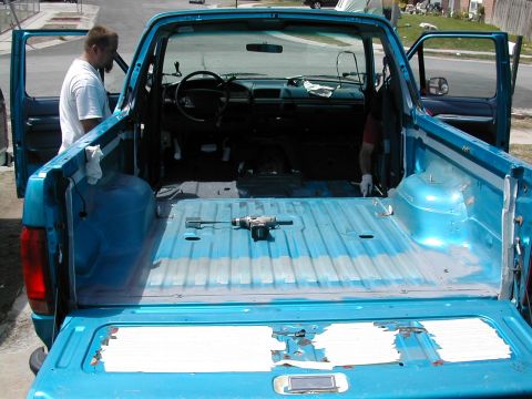 1994 Ford Bronco - Interior view of a blue pickup truck bed and cabin, showing a drill and some repair work in progress.