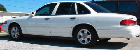 1997 Ford Crown Victoria - Side view of a white 1997 Ford Crown Victoria sedan parked outdoors.