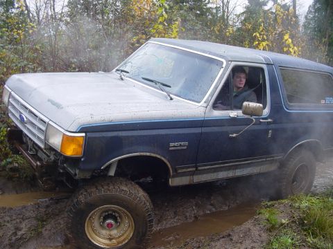 1987 Ford Bronco - This 1987 Ford Bronco navigates a muddy trail, kicking up spray as it goes.