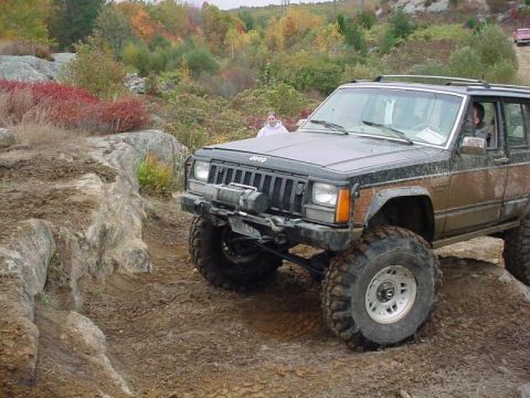 1978 Ford Bronco - A lifted Jeep Cherokee XJ navigates a rocky, off-road trail during autumn.